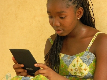 Garota lendo em dispositivo eletrônico
